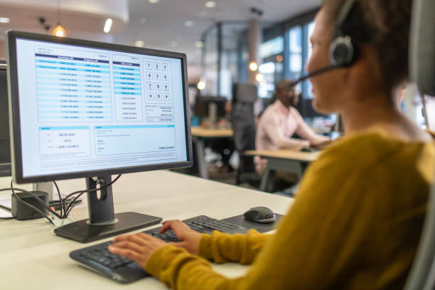 Over-the shoulder view of a woman working in a call center for IT support